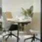 Mūsdienīga sanāksmju telpa ar mīkstiem biroja krēsliem un galdu.